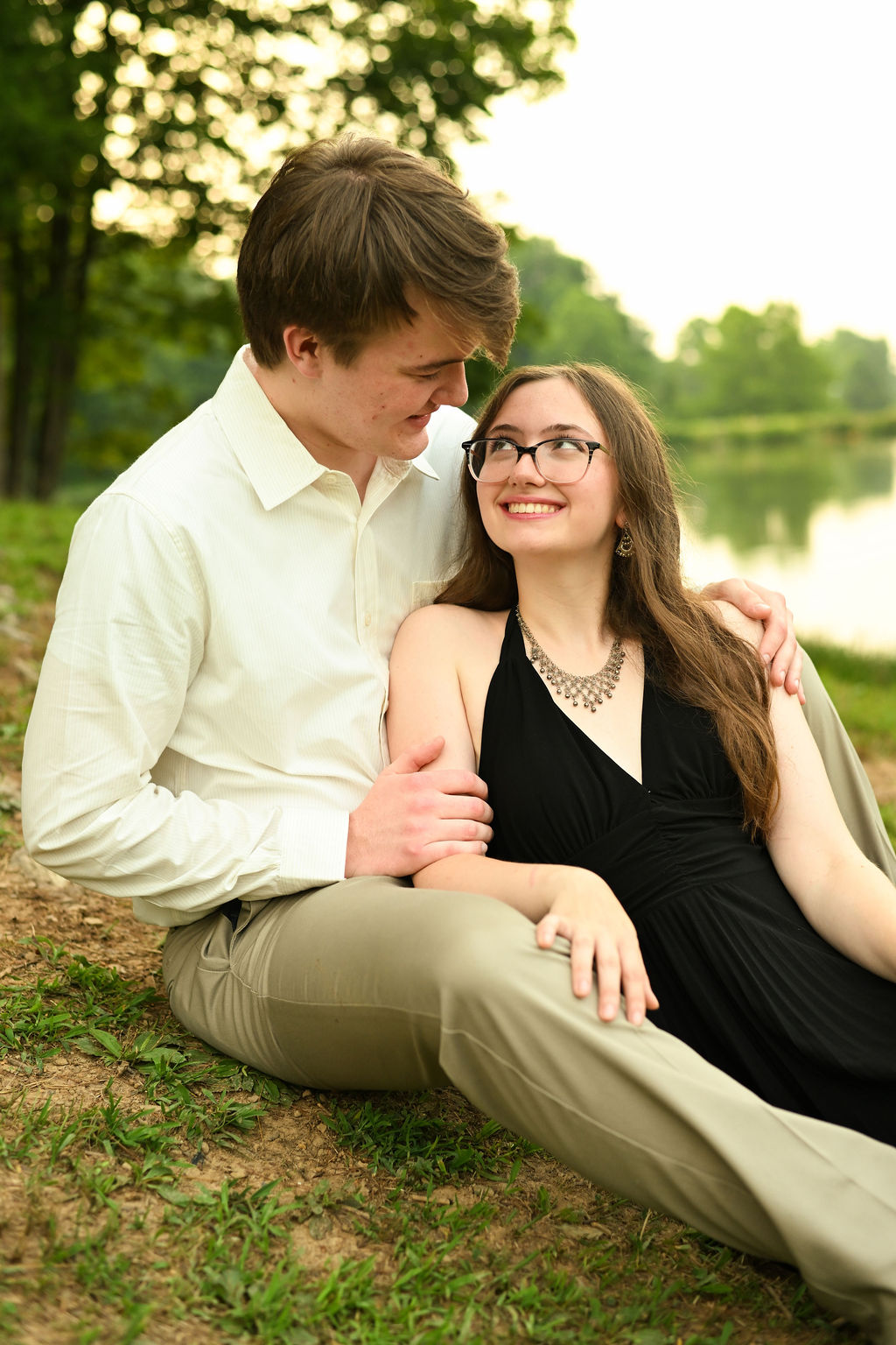 Cole and Abigail sitting together beside a lake